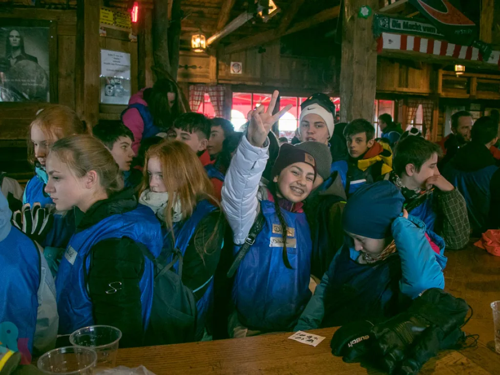 Jugendliche lachen und winken in der Hütte.